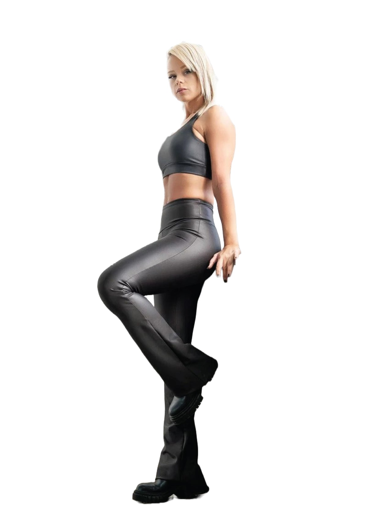 Eine Frau in Lisminas 1169 Extra High Waist Schlagleggings in Schwarz mit Lederoptik steht vor einem weißen Hintergrund.