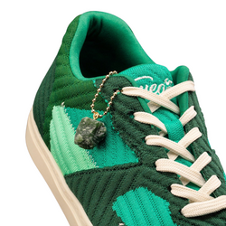 Fuego Jade Dance Sneakers in Grün mit weißen Schnürsenkeln und einem grünen Edelsteinanhänger an der Öse von Fuego Dance Shoes.