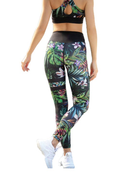 Person in Lismina 876-Leggings mit schwarz-grünem Blumendruck, dazu ein Sport-BH und weiße Sneakers.