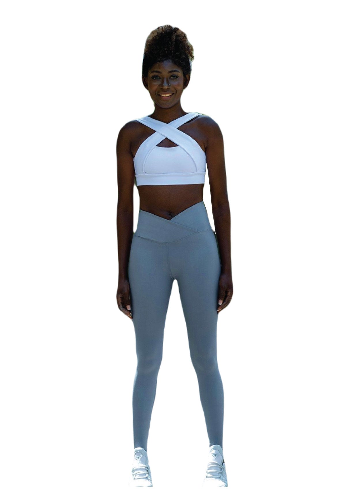 Person in einem weißen V-Ausschnitt-Tanktop und Lismina 1097 Ve Waist Leggings in Wasserblau lächelt vor einem schlichten Hintergrund.