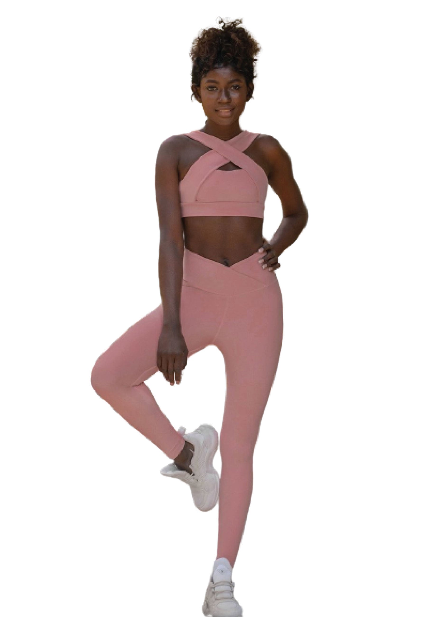 Person im rosafarbenen Lismina Crossover-BH und 1099 Ve Waist Leggings in Rose, ein Bein hochgezogen, in weißen Sneakers.