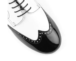 Nahaufnahme der Tango-Tanzschuhe PD042 von Portdance aus schwarz-weißem Leder mit Schnürsenkeln und Brogue-Details.