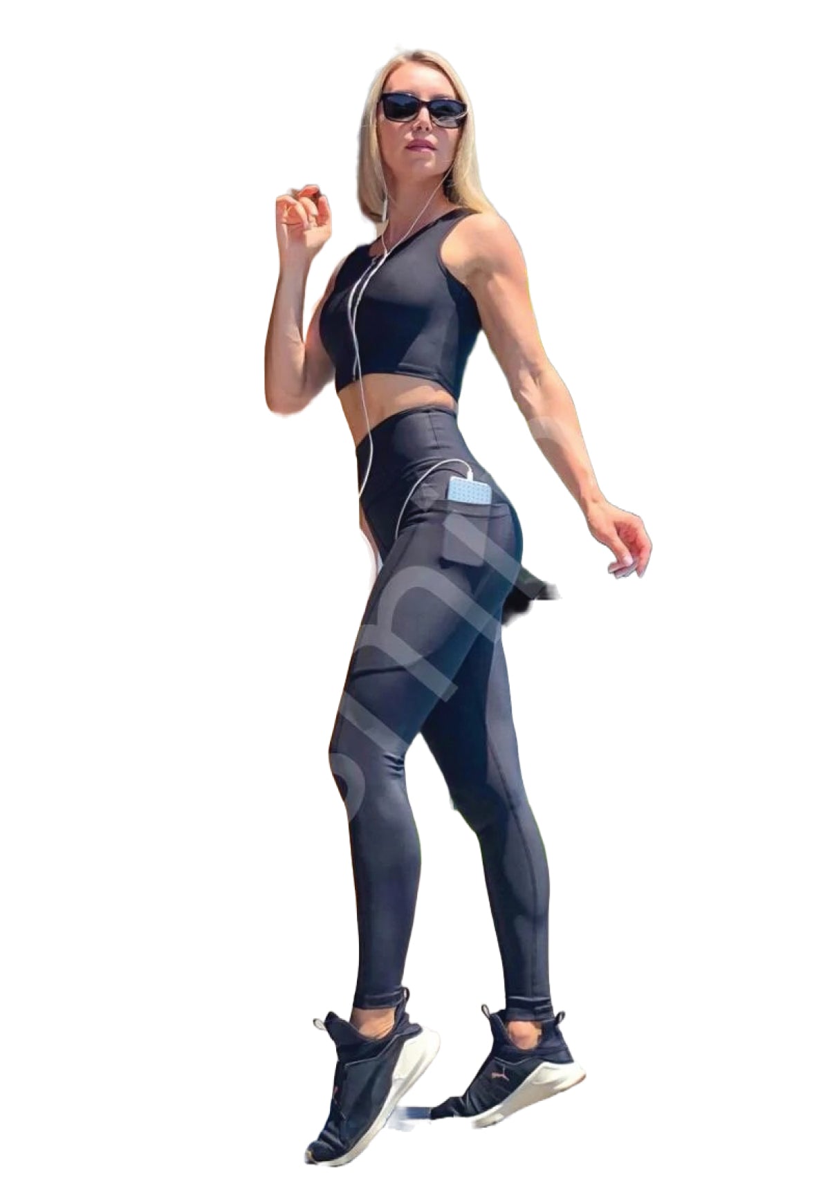 Frau in Lismina 772 Pocket Extra High Waist Leggings und Sonnenbrille hört beim Gehen Musik.