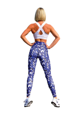 Person im weißen Sport-BH Lismina und 1037 Extra High Waist Leggings, Blau & Weiß gemustert, Hände auf den Hüften.