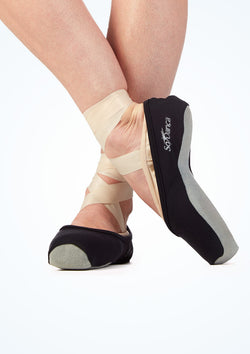 Nahaufnahme der Füße einer Balletttänzerin auf Spitze in AC09 Só Dança Spitzenschuh-Überzieher in Schwarz von Rumpf, auf Weiß.