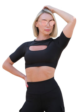 Eine Person in Lisminas 073 Schwarz T-Shirt und Sonnenbrille, die verführerisches Flair auf weißem Hintergrund zeigt.